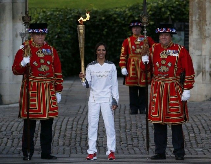 Britain&#039;s Holmes holds the London 2012 Olympic torch as she poses with Yeoman Warders at the Tower of London
