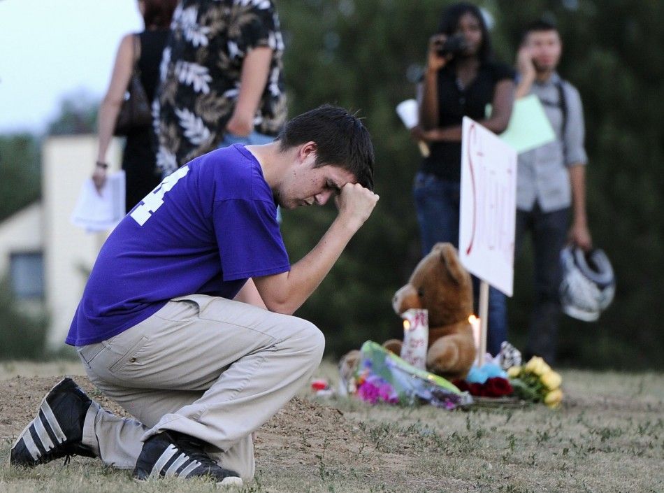 A man prays during a vigil for victims behind a theater where a gunman opened fire in Aurora, Colorado.