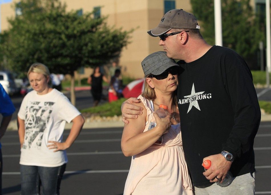 A couple embraces before a vigil for victims behind the theater where a gunman opened fire in Aurora, Colorado