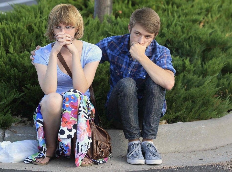 People grieve during a vigil for victims behind the theater where a gunman opened fire in Aurora, Colorado