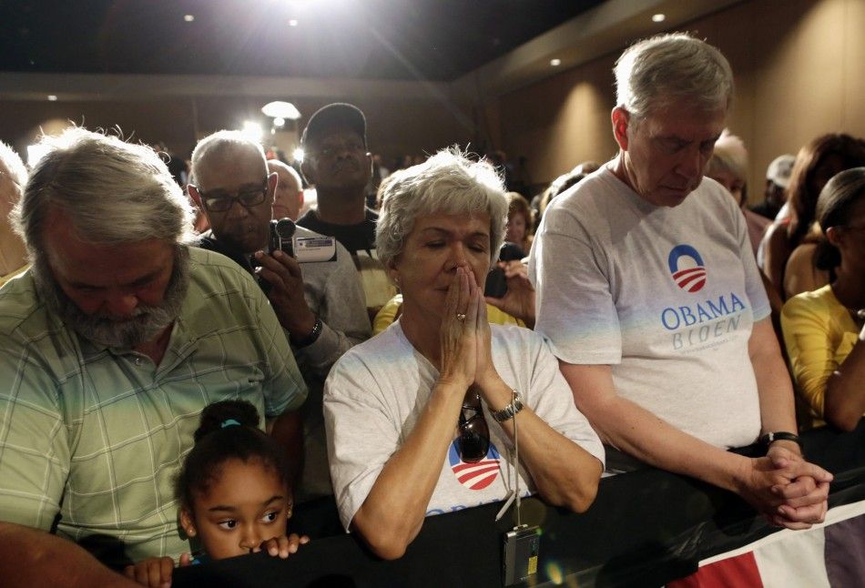  People bow in moment of silence with U.S. President Obama for victims of Colorado shootings in Fort Myers