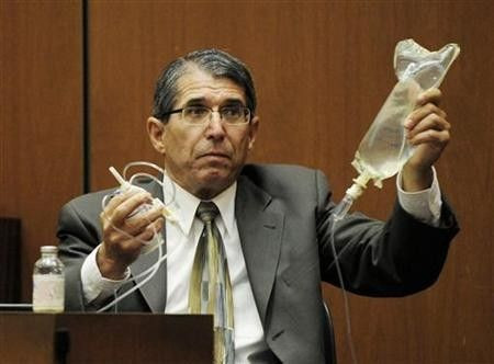 Dr. Paul White, an anaesthesiologist and propofol expert, holds up an IV drip in the final stage of Dr. Conrad Murray's defense case, during Murray's involuntary manslaughter trial in Los Angeles