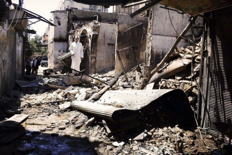 People look at damage at al-Midan neighbourhood in Damascus July 23, 2012.