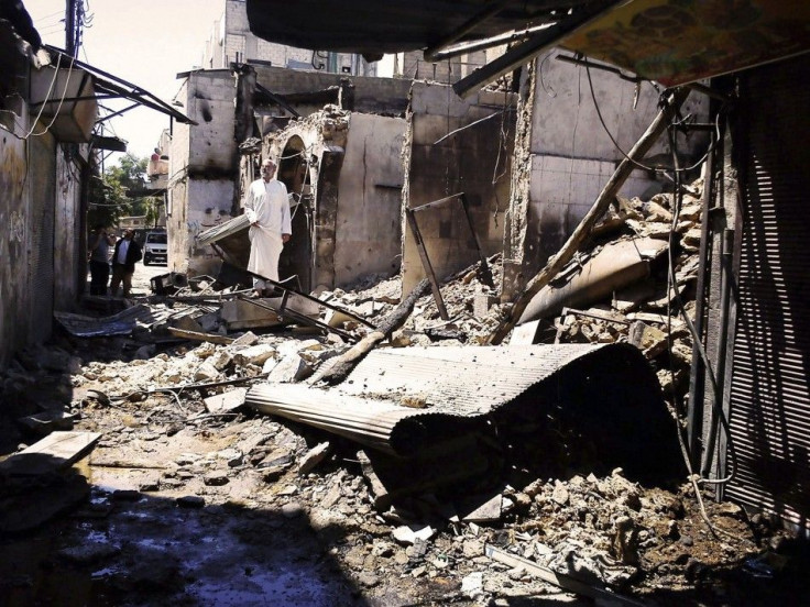 People look at damage at al-Midan neighbourhood in Damascus July 23, 2012.