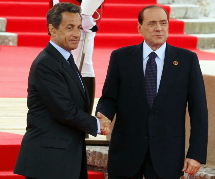 Berlusconi shakes hands with Sarkozy before the start of the G8 Summit in Deauville