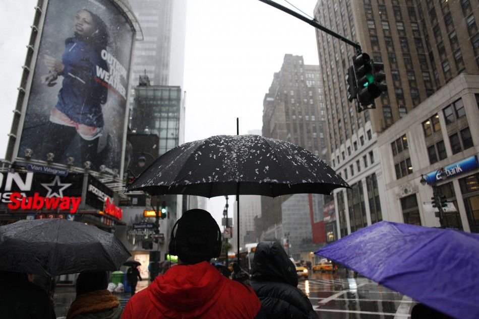 Snow and ice are seen on the umbrella of a pedestrian as he waits to cross the street in New York, October 29, 2011. A rare October snowstorm bore down on the heavily populated U.S. Northeast on Saturday, with some areas bracing for up to a foot 30 cm o