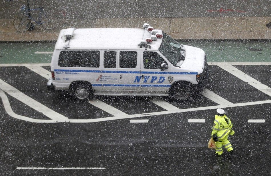 A New York Police officer walks back to their van during a snowstorm in New York, October 29, 2011. A rare October snowstorm bore down on the heavily populated U.S. Northeast on Saturday, with some areas bracing for up to a foot 30 cm of snow and major 