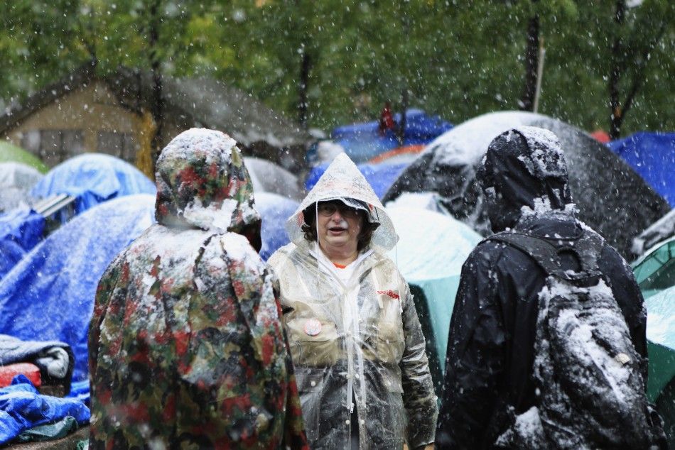 Members of the Occupy Wall Street movement discuss the weather while standing in Zuccotti Park during the first snow fall of winter in New York October 29, 2011.