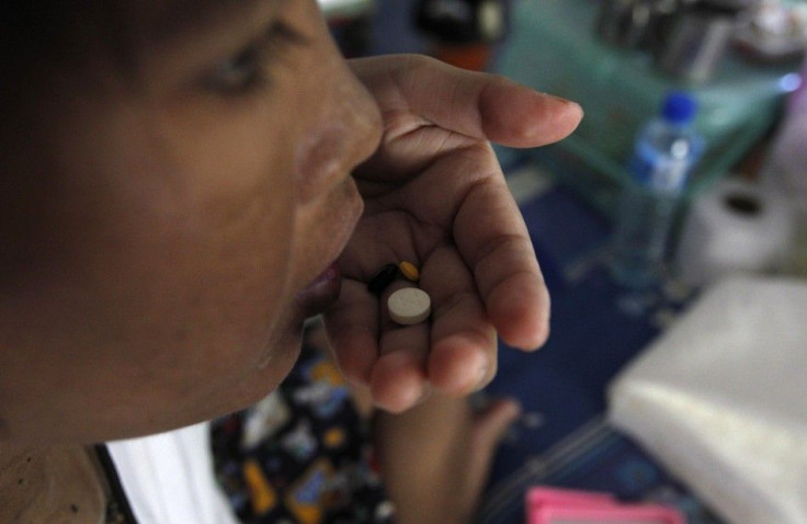 A patient eats a dose of generic HIV/AIDS drugs at a hospice for those dying of AIDS, at Wat Prabat Nampu Buddhist temple in Lopburi