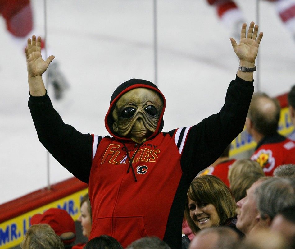 Man dressed as an alien cheers for the Flames during NHL hockey game against the Red Wings during Halloween night in Calgary