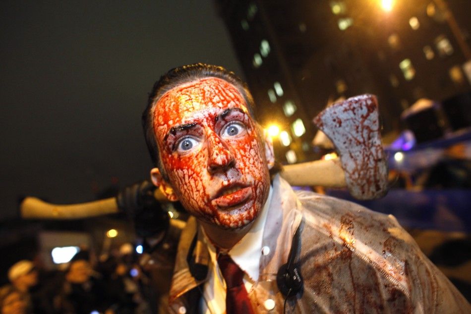 A man covered in fake blood carries an axe as he participates in the annuall Halloween parade in Greenwich Village in New York