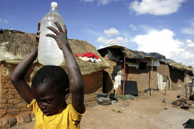 A boy carries a container of water in the suburb of Epworth in Zimbabwe&#039;s capital Harare
