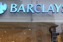 A worker carries out maintenance in a branch of Barclays bank in London