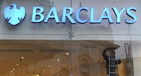 A worker carries out maintenance in a branch of Barclays bank in London