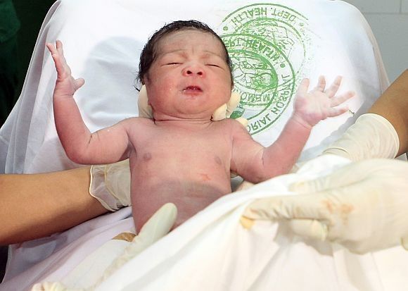Midwives hold the newborn baby girl named, Danica Camacho, the seven billionth baby, at the Fabella Maternity hospital in Manila on October 31.