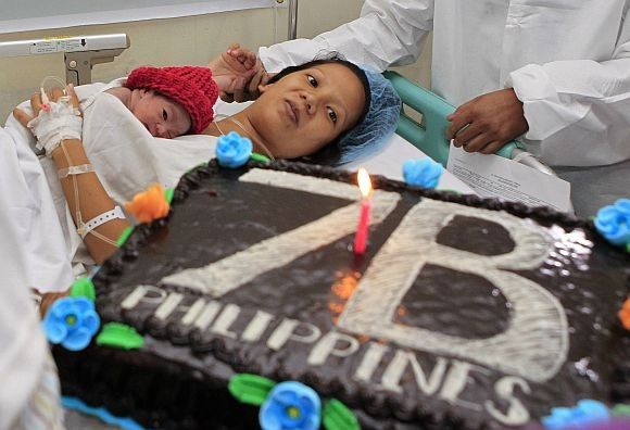 United Nations Population Fund staff presents a cake to the family of newborn baby girl, Danica Camacho.
