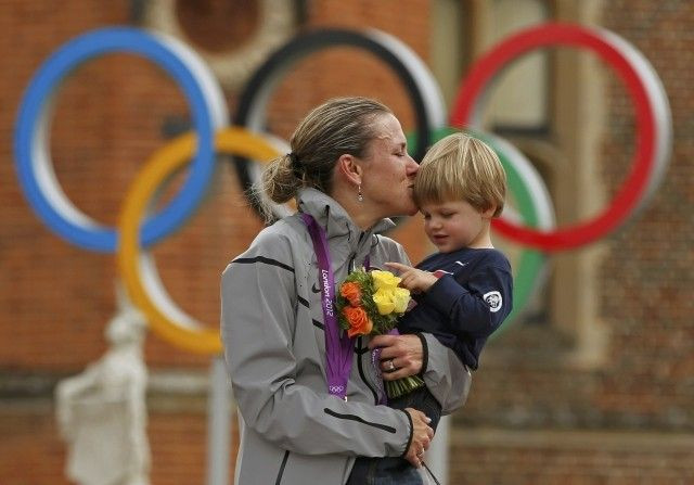Gold medallist Kristin Armstrong of the U.S celebrates with her son Lucas William Savola on the podium during the victory ceremony of the women's cycling individual time trial at the London 2012 Olympic Games