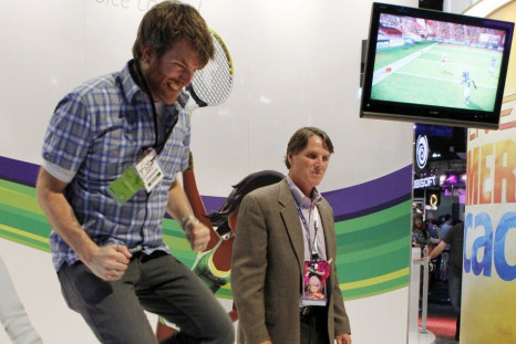 A Microsoft employee jumps as he and an attendee play Kinect Sports Season Two at the Microsoft XBOX 360 booth at E3 in Los Angeles