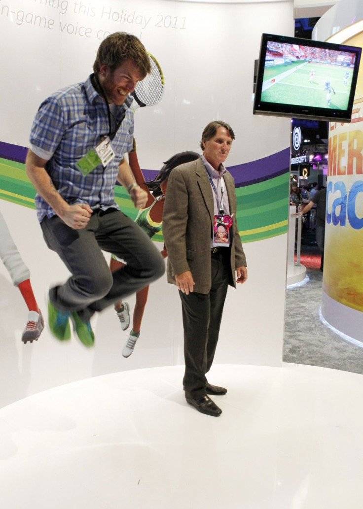 A Microsoft employee jumps as he and an attendee play Kinect Sports Season Two at the Microsoft XBOX 360 booth at E3 in Los Angeles