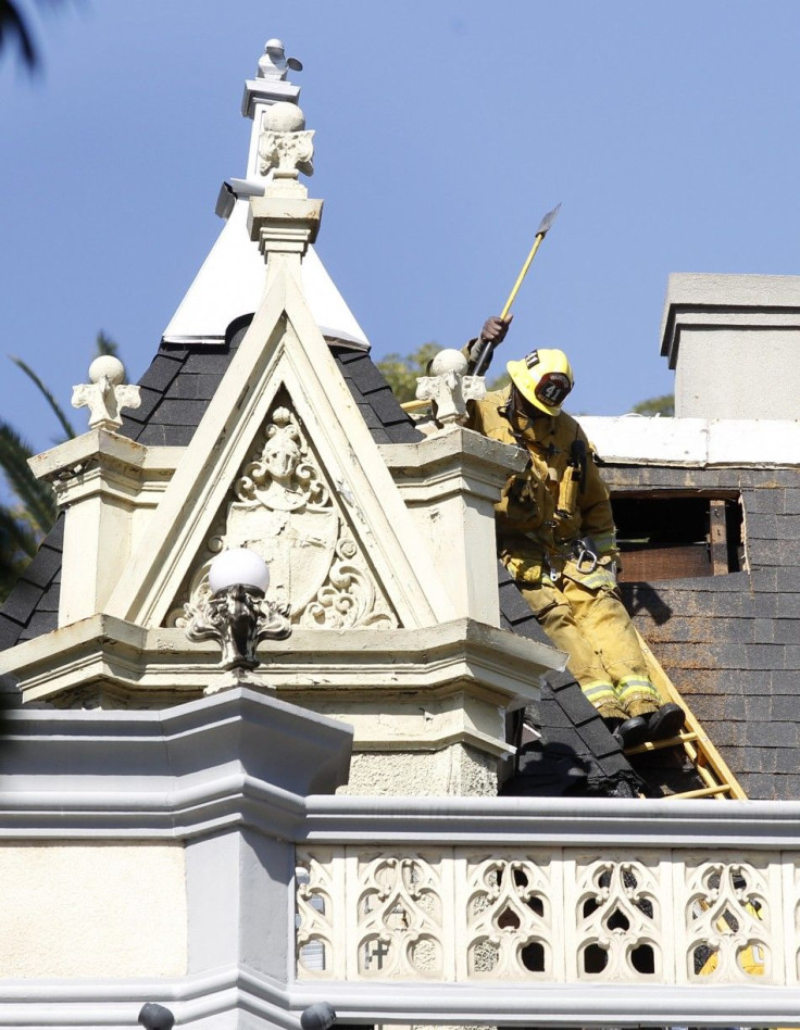 A firefighter is seen on the roof of the Magic Castle after an attic fire broke out in Hollywood