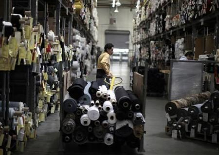 A worker wheels rolls of cloth through the Karen Kane clothing company in Los Angeles