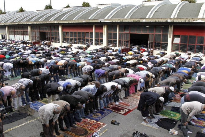 Muslims celebrate Friday prayers outside in the courtyard of a former fire brigade in Paris