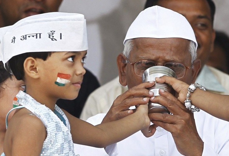 A child offers coconut water and honey to Indian social activist Hazare to end his fast in New Delhi