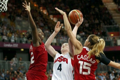Whalen of the U.S. goes between Turkey&#039;s Hollingsvorth and Caglar during their Women&#039;s preliminary round group A basketball match at the Basketball Arena during the London 2012 Olympic Games