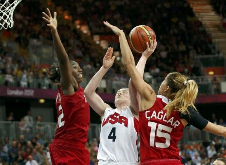 Whalen of the U.S. goes between Turkey&#039;s Hollingsvorth and Caglar during their Women&#039;s preliminary round group A basketball match at the Basketball Arena during the London 2012 Olympic Games