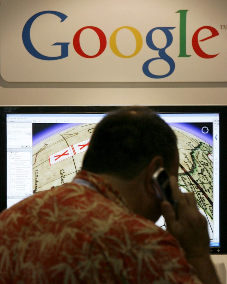A SIGGRAPH attendee talks on a cell phone as he views a display of Google Maps at SIGGRAPH 2007 in San Diego