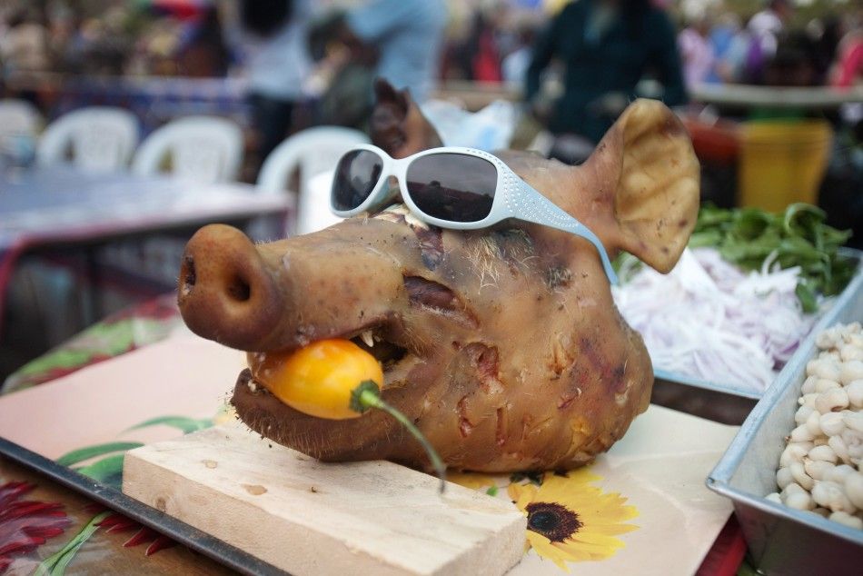 The head of a pig with a chilli in its mouth rests on a food stand outside Nueva Esperanza cemetery during the Day of the Dead celebrations in Villa Maria, Lima November 1, 2011.
