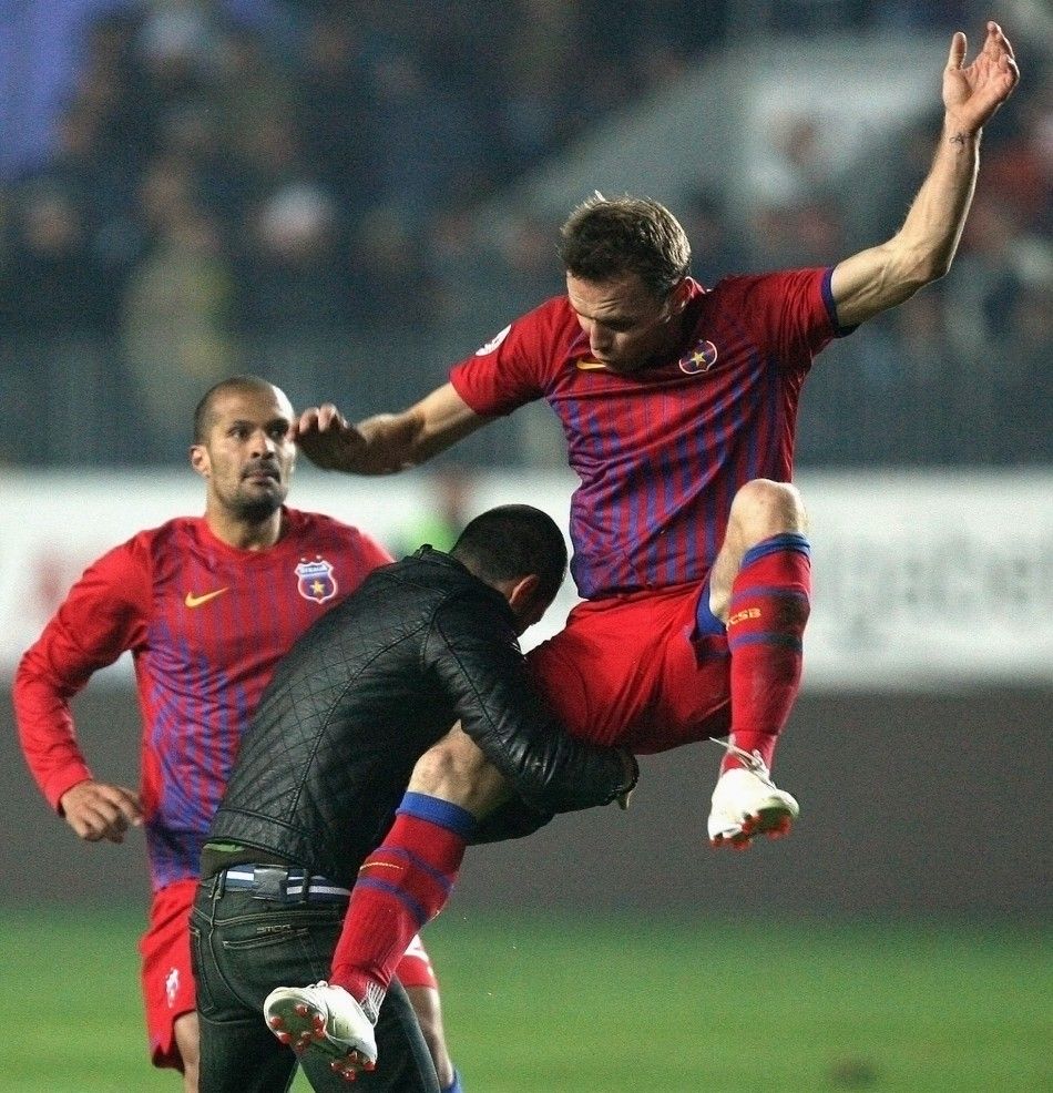 Novak Martinovic of Steaua Bucharest R kicks a Petrolul supporter after he attacked two teammates during their ill-tempered league match in Ploiesti, October 30, 2011.