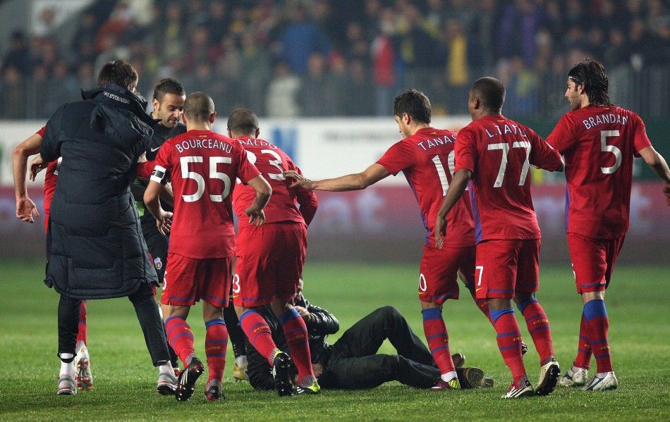 Steaua Bucharest players kick a Petrolul supporter after he attacked two teammates during their ill-tempered league match in Ploiesti