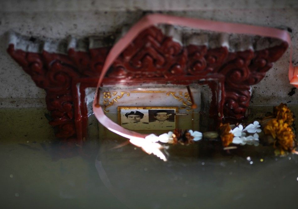 A submerged grave with pictures is seen at a flooded Buddhist temple in Bangkok November 1, 2011.