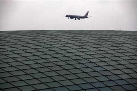 An Air China plane comes in to land over the roof of the railway station at Beijing&#039;s internationl airport