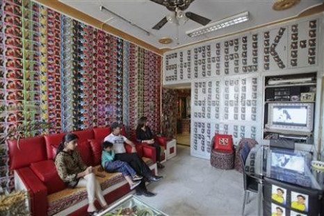 Vishal Singh (2nd R), 38, sits in his living room with his 35-year-old wife Ruchi Singh (R), 15-year-old daughter Simran (L) and five-year-old son Aryan in Lucknow October 24, 2011. Singh is a fan of the Bollywood actor Shah Rukh Khan and has more than 22