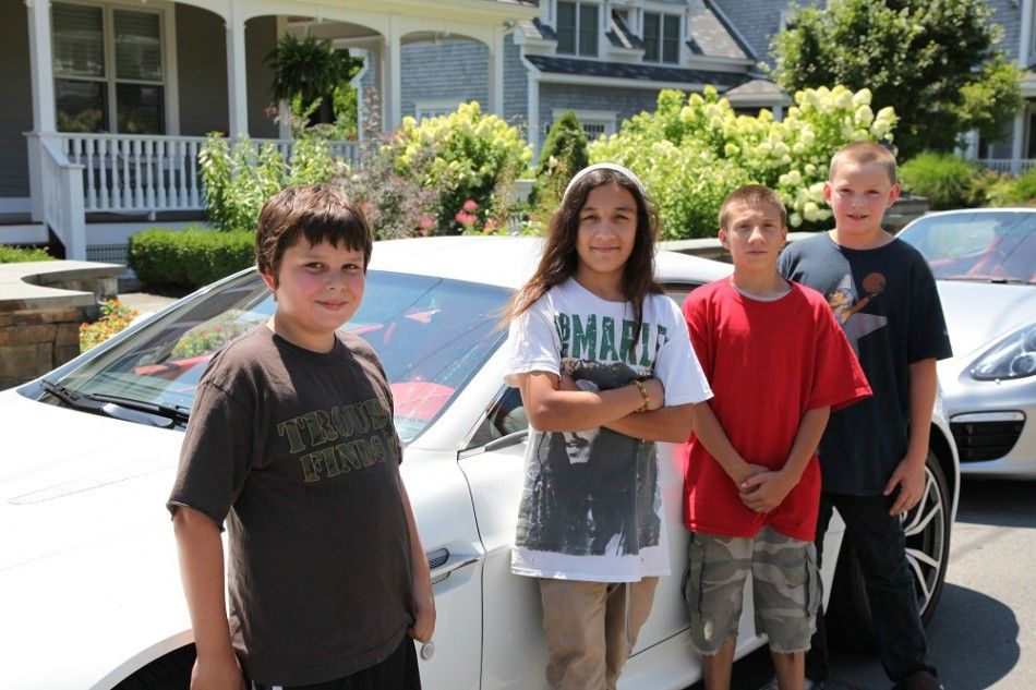 Four neighborhood children stand for a picture in front of the cars in Saratoga Springs.