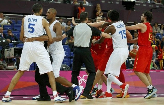 Officials try to separate the players of Spain and France after a hard foul by France's Batum during their men's quarterfinal basketball match