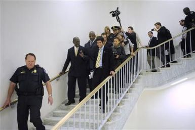 Republican presidential candidate Herman Cain is surrounded by police and reporters as he departs following remarks to legislators in the Congressional Health Care Caucus on Capitol Hill