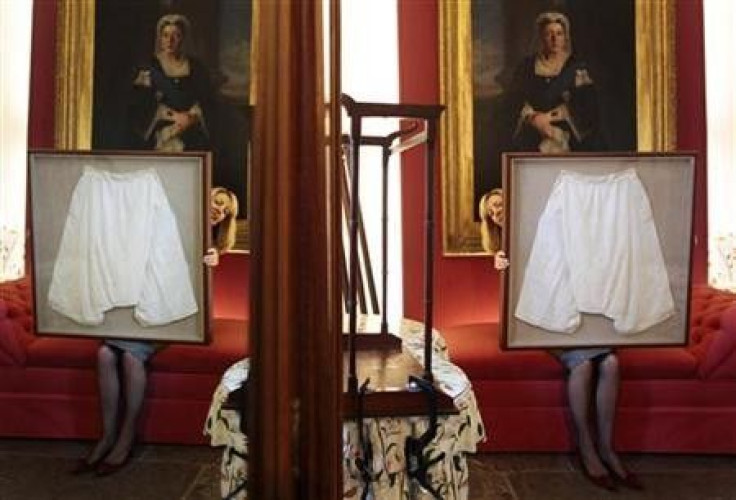 Kate Bain from Lyon and Turnbull auctioneers poses for photographers with a framed pair of silk bloomers undergarments that once belonged to Queen Victoria, during a photocall for the auction of the Forbes Collection in Edinburgh, Scotland