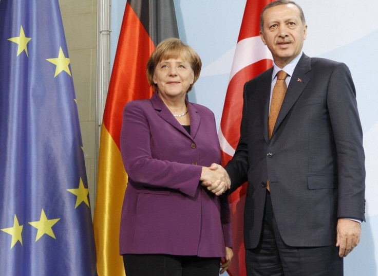 German Chancellor Angela Merkel and Turkish Prime Minister Tayyip Erdogan shake hands as they speak to media after meeting in the Chancellery in Berlin