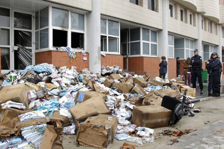 French police stand in front of the damaged offices of French satirical magazine Charlie Hebdo in Paris November 2, 2011.