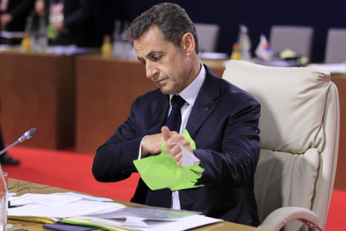 France&#039;s President Sarkozy tears up some papers as he waits for the start of talks at the G20 Summit in Cannes