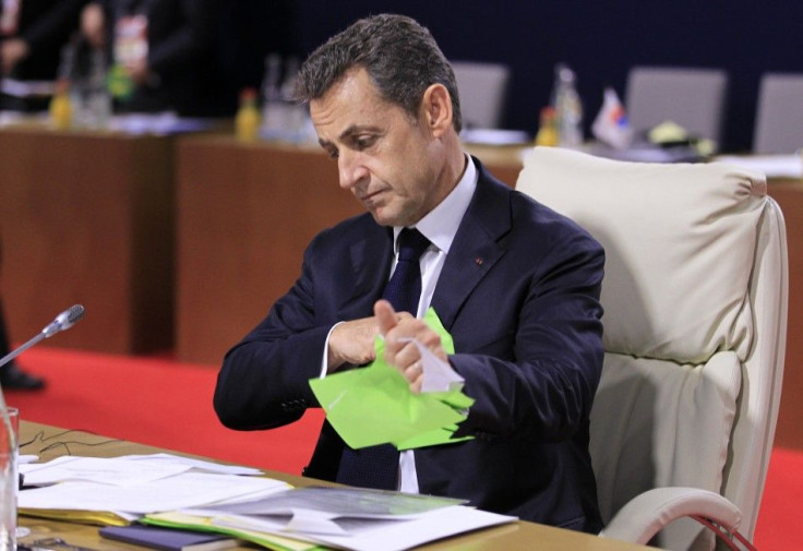 France&#039;s President Sarkozy tears up some papers as he waits for the start of talks at the G20 Summit in Cannes
