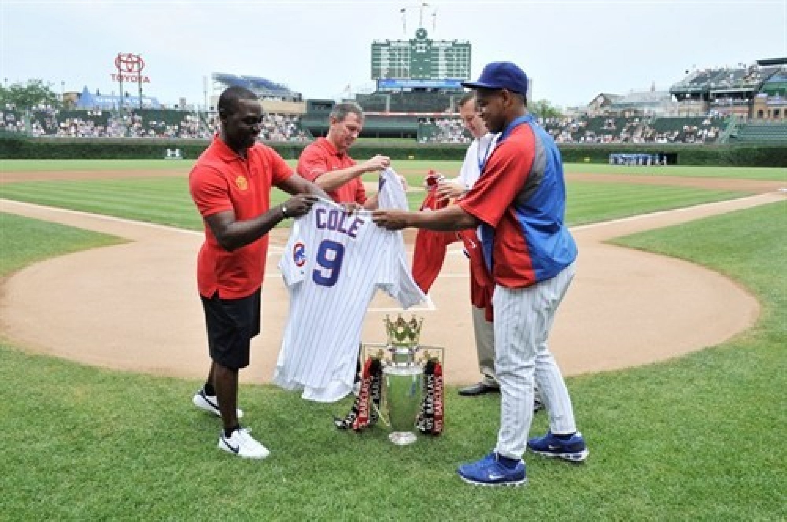 Reds legends Andy Cole and Bryan Robson exchanging shirts with Chicago Cubs owner Tom Ricketts and pitcher Carlos Marmol before a game against Houston Astros.