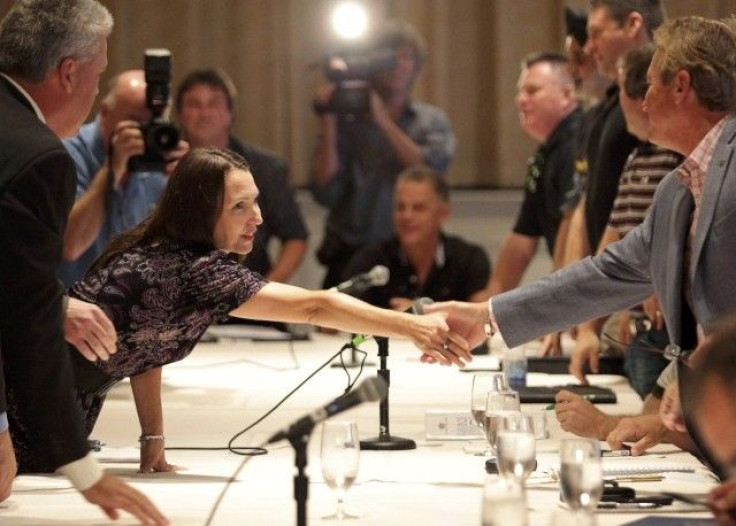 Oliva, Chrysler Canada&#039;s Labour Relations representative, shakes hands with Kennedy, CAW national secretary treasurer, while CAW representatives prepare to discuss contract negotiations with Chrysler Canada representatives, in Toronto