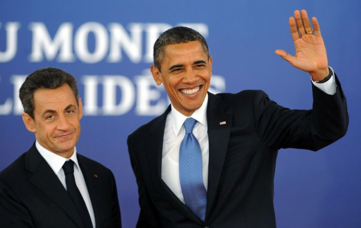 U.S. President Barack Obama waves as he is greeted by France's President Nicolas Sarkozy before the start of the G20 Summit of major world economies in Cannes