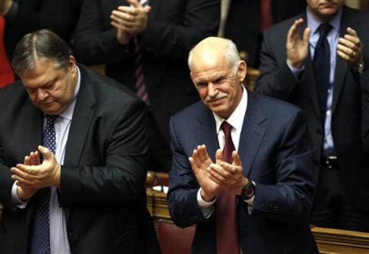 Greek PM George Papandreou and FM Evangelos Venizelos applaud after winning a vote of confidence in the Greek parliament in Athens