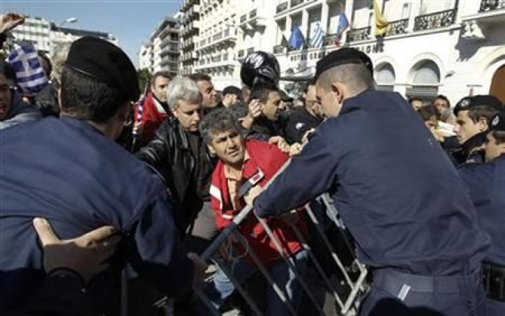 Greeks scuffle with policemen as they protest against austerity policies during a students parade in Athens