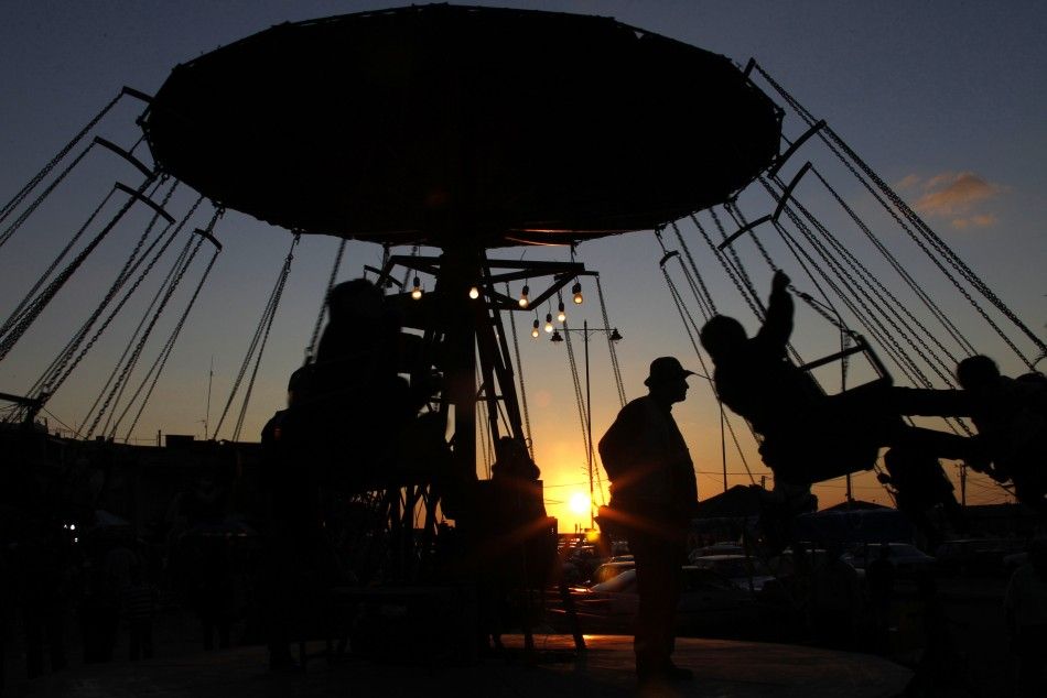 Children ride on a swing carousel during the first day of Eid al-Adha, at the port-city of Sidon, southern Lebanon, November 6, 2011.